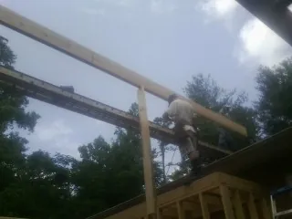 Carpenter setting a ridge beam over a new addition frame — Ice Dam Removal by Roofing Brothers in Haydenville