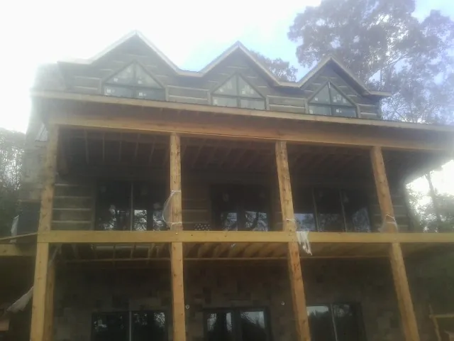 Dormers and porch framing on a large log home under construction — Roof Coating work by our crew in Haydenville